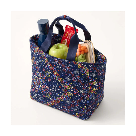 Navy patterned insulated lunch tote with double handles, filled with a water bottle, apple, snack pack, and lunch container