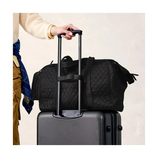 Black quilted weekender bag secured over a suitcase handle