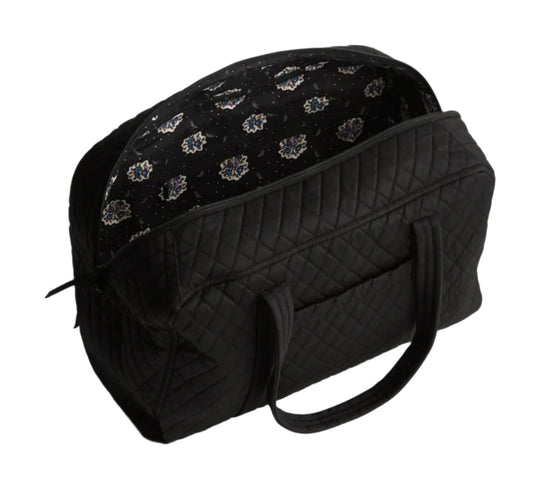 Black quilted weekender bag with patterned top panel and shoulder straps