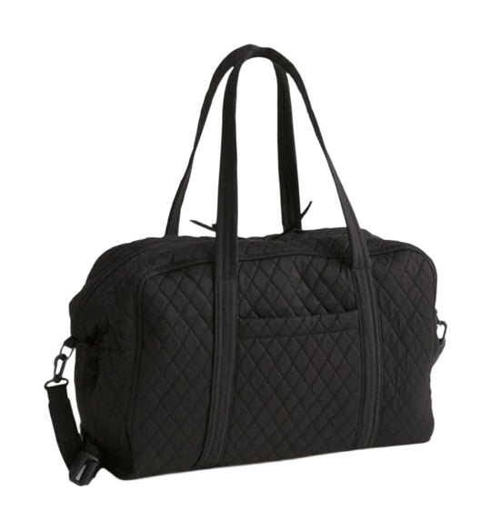 Black quilted weekender bag with long handles and a detachable shoulder strap