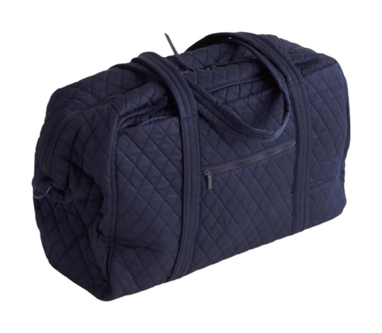 Quilted navy duffel bag with double handles, exterior zip pockets, and a padded body