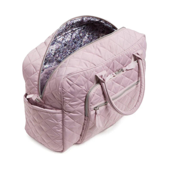 Pink quilted weekender bag with zip-top opening, front pockets, and dual handles