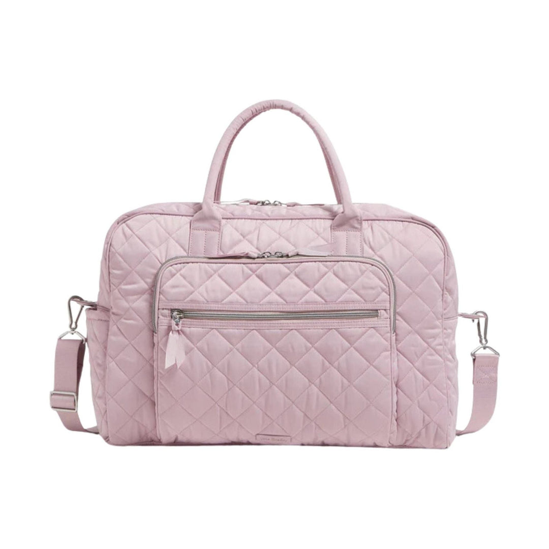 Light pink quilted weekender bag with top handles, detachable shoulder strap, and front zip pocket