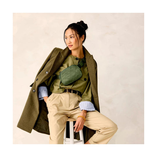 Olive quilted belt bag worn crossbody over a model’s chest