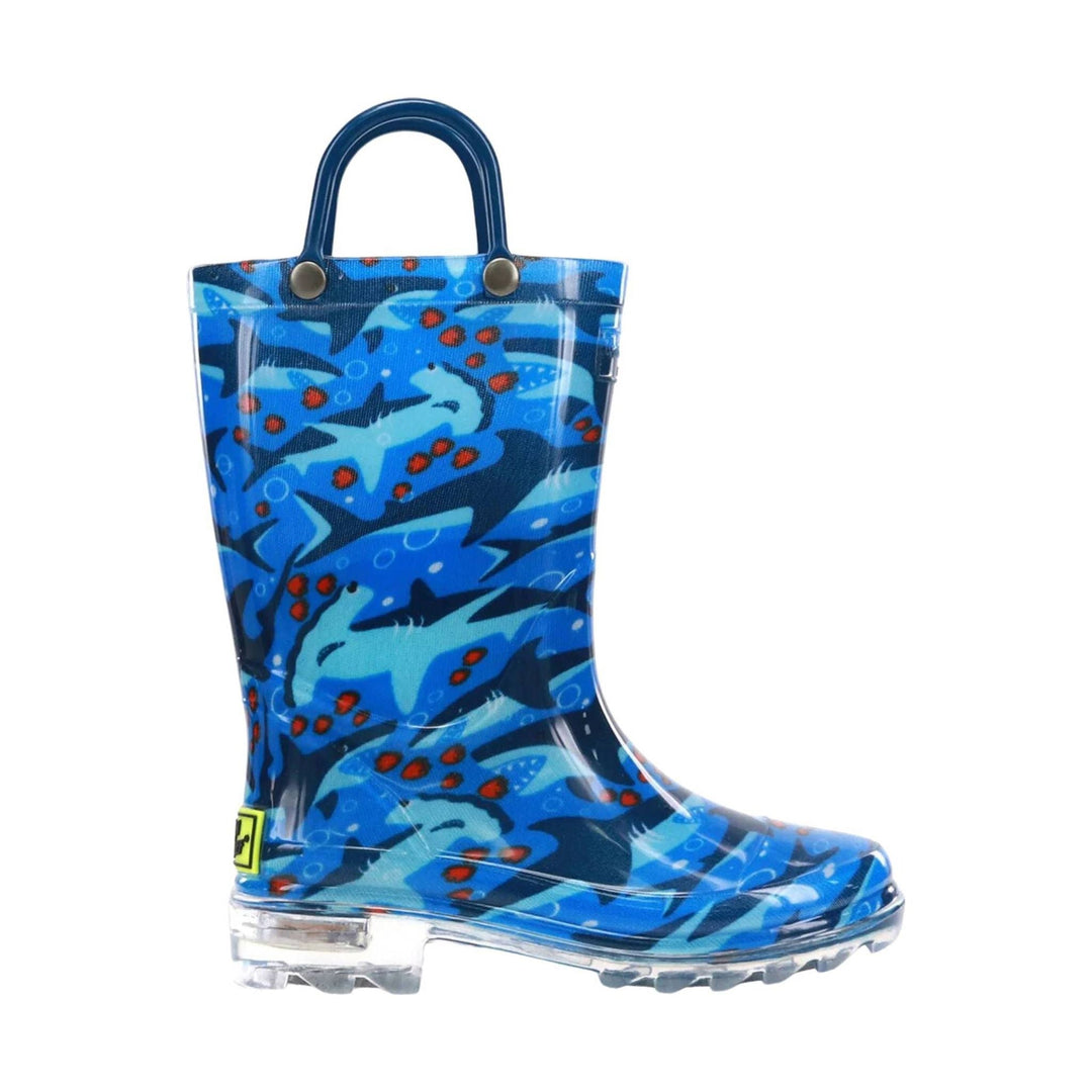 Blue children’s rain boot with shark pattern, clear sole, and pull handle
