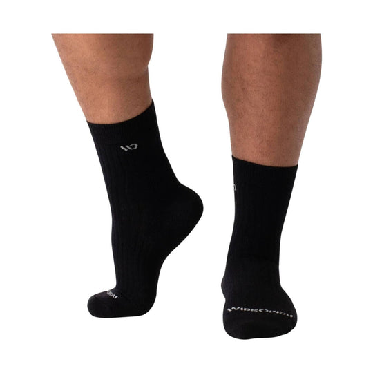 Black mid-calf crew socks shown on two lower legs, with small white logo text near the ankle and toe.
