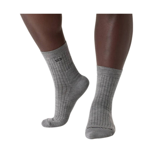 Gray ribbed crew socks on a model’s lower legs, with a small logo near the ankle