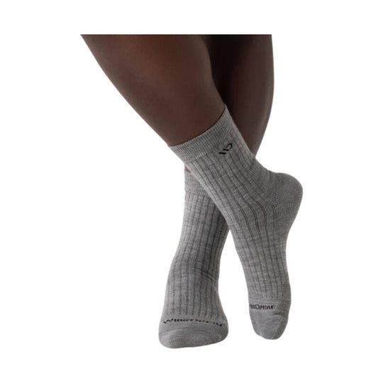 Light gray ribbed crew socks on crossed legs, with small black logo near the cuff