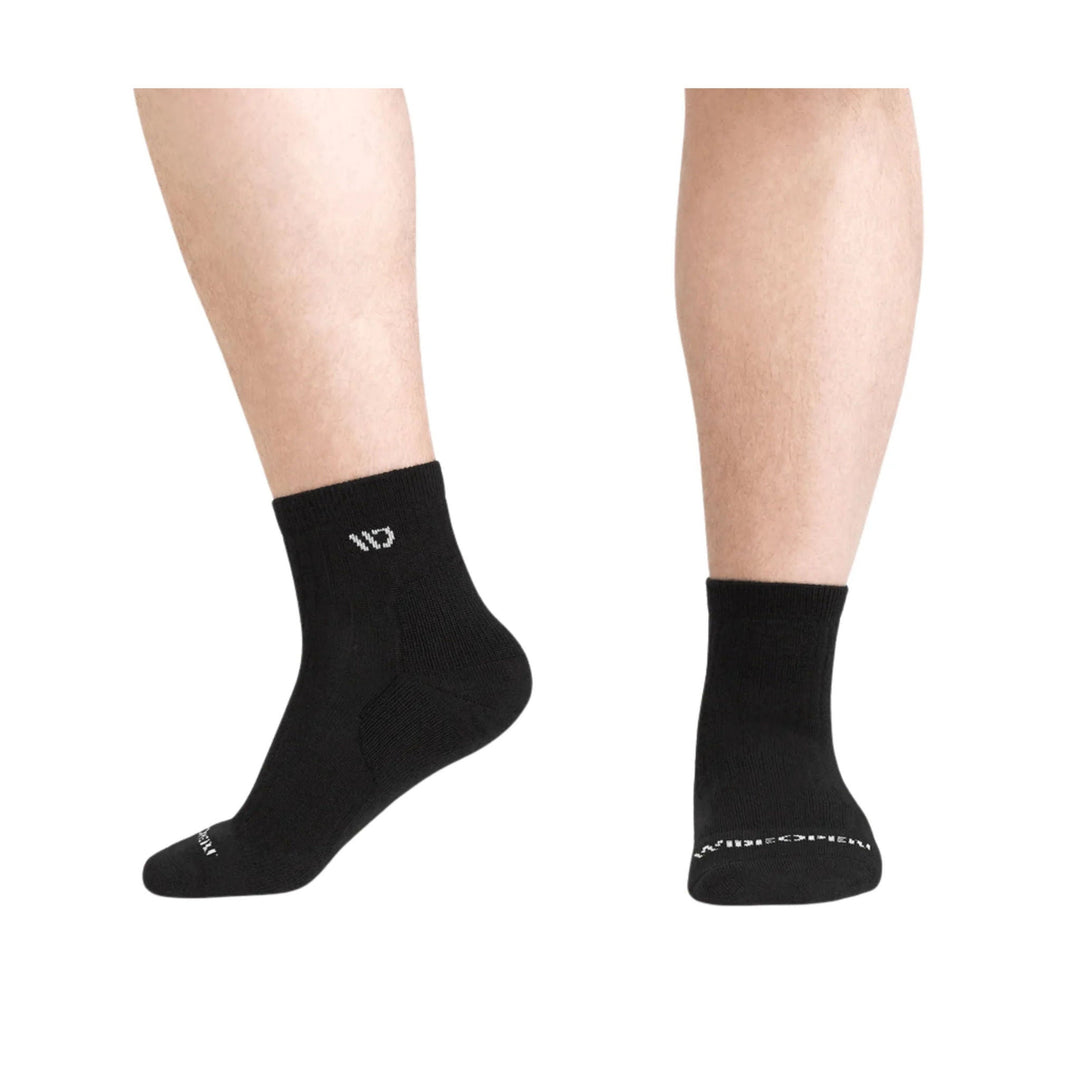 Black ankle socks shown on a model's lower legs, with small white logo details and cushioned heels