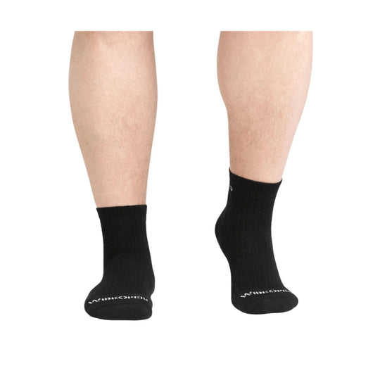 Black ribbed quarter socks shown on a model’s lower legs, with white logo text at the toes
