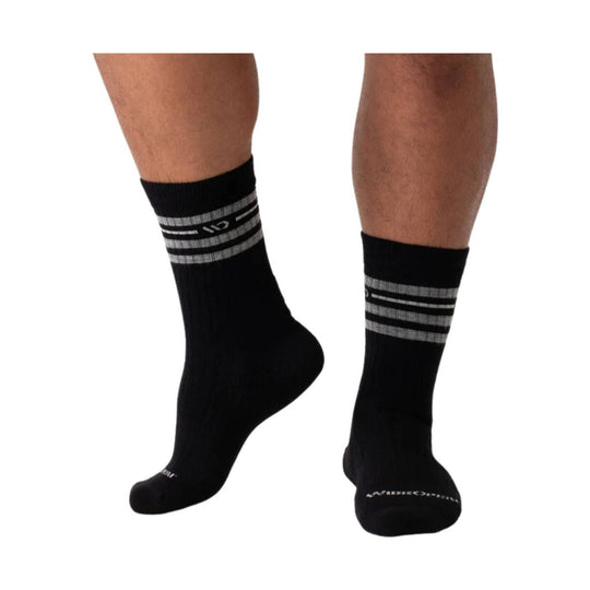 Black crew socks with gray horizontal stripes and visible logo text near the cuff, shown on lower legs from side and front.