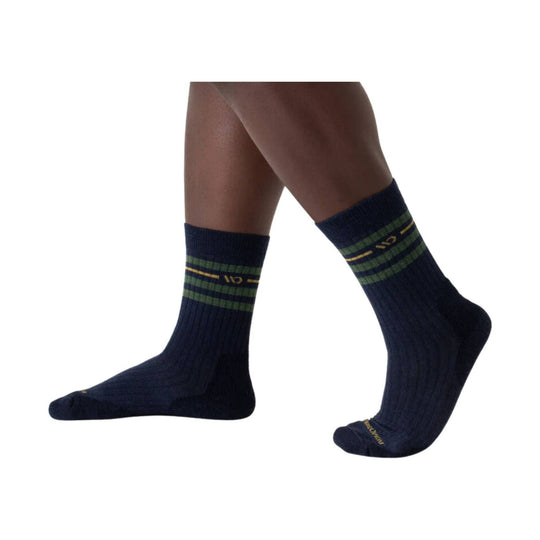 Navy crew socks with green and gold striped cuffs on a model's legs
