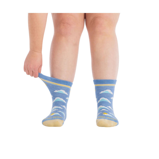 Blue patterned micro crew socks with clouds and yellow trim, worn on one foot and being pulled on