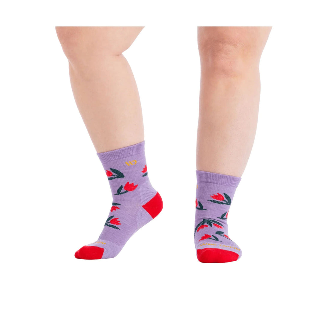 Lavender crew socks with red toe and heel, shown on both lower legs, with red and green floral print