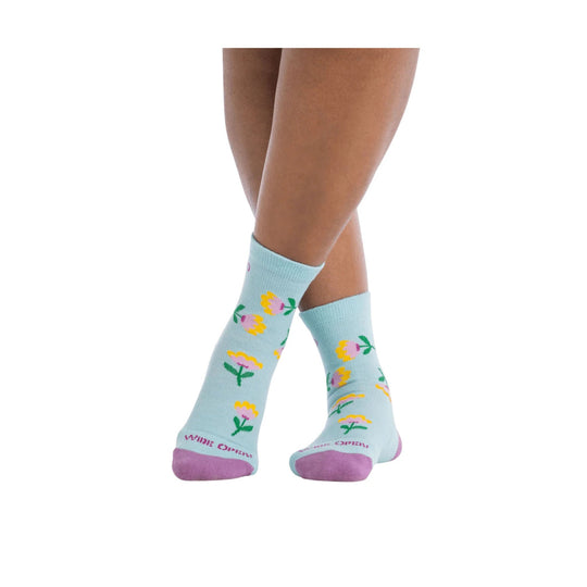Light blue floral crew socks with pink heels and toes, shown on crossed legs.