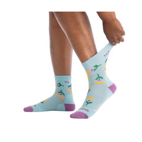 Light blue crew socks with pink toe and heel, green floral print, shown on a model's legs
