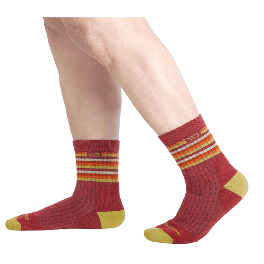 Red crew socks with yellow toes and heels and multicolor striped cuffs on a model's lower legs