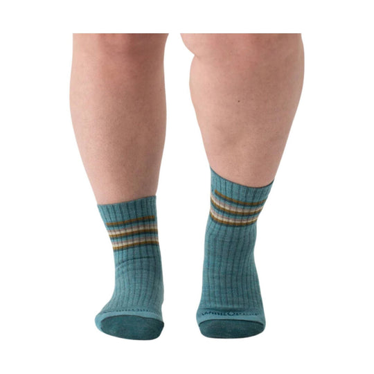 Light teal ribbed crew socks with horizontal multicolor stripes near the cuffs, shown on legs from the back.