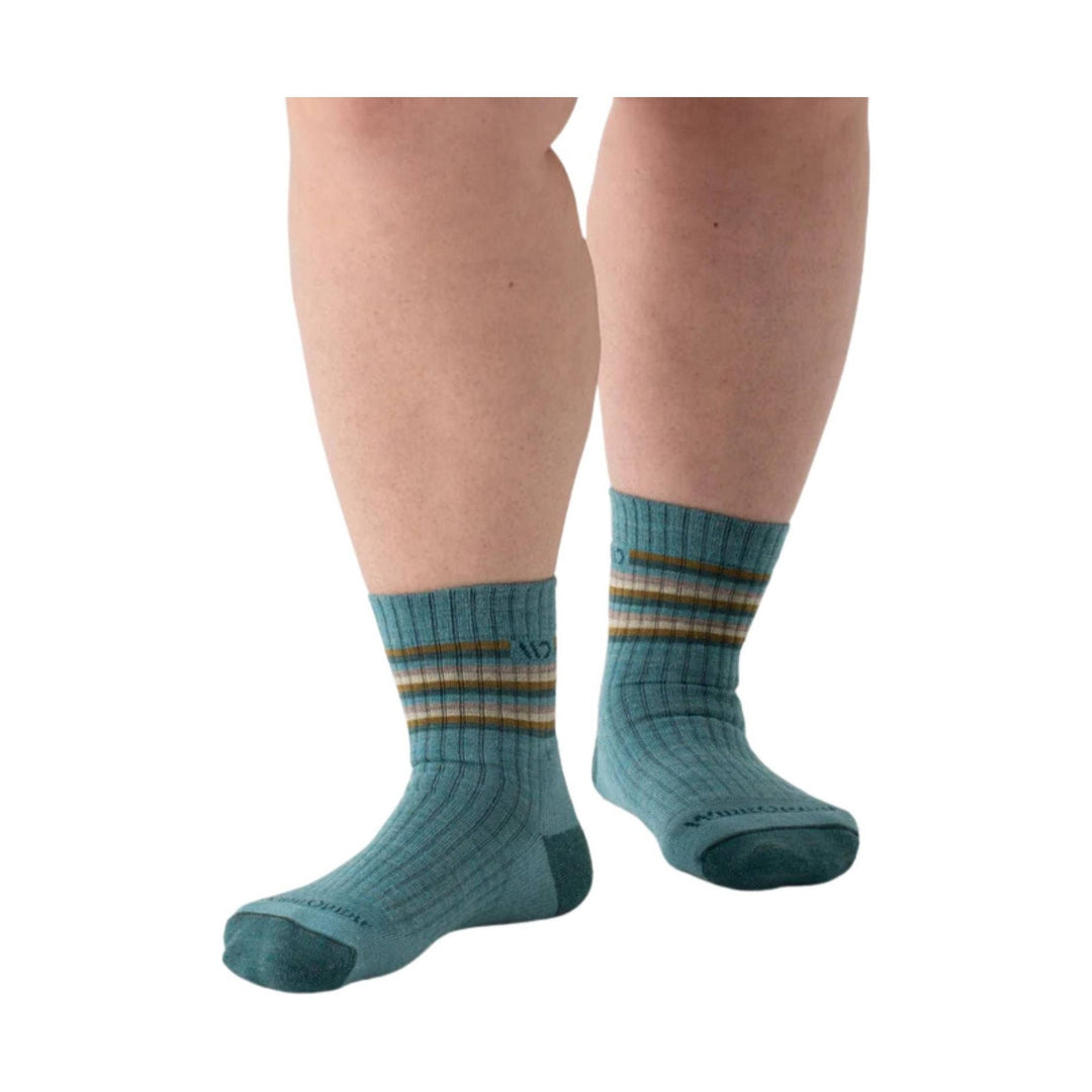 Light teal crew socks with multicolor horizontal stripes and ribbed knit, worn on legs against a white background.