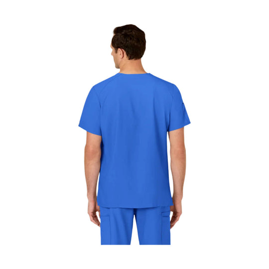 Back view of a royal blue scrub top on a model, with matching scrub pants visible.