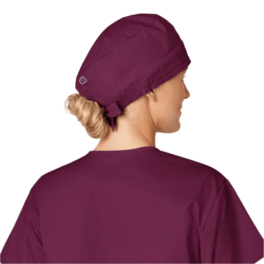 Back view of a plum scrub cap on a model with hair in a bun