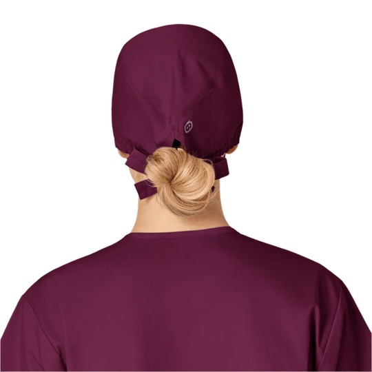 Back view of a burgundy scrub cap tied at the nape over a blonde bun