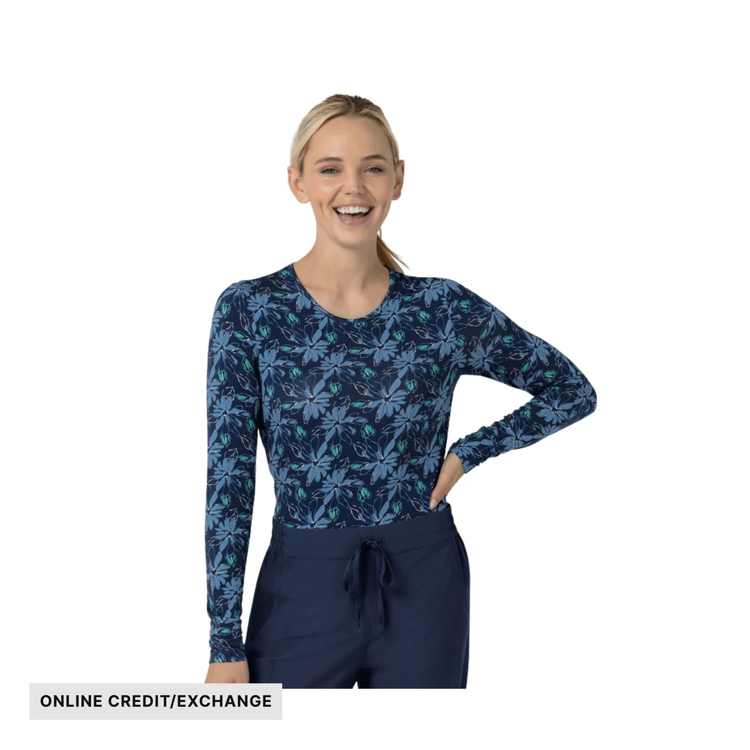 Long-sleeve floral print scrub top with navy pants and an "ONLINE CREDIT/EXCHANGE" label