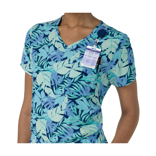 Blue and teal tropical print scrub top with V-neck, short sleeves, and a clipped-on tag