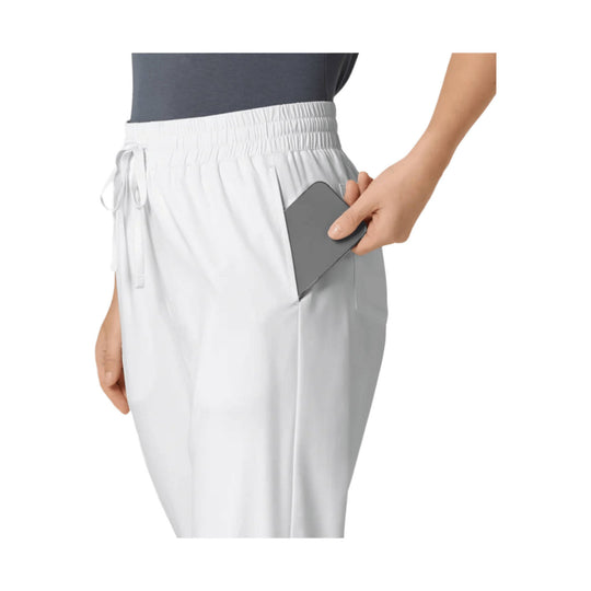 White athletic pants with an elastic waistband and side pocket, shown on a model