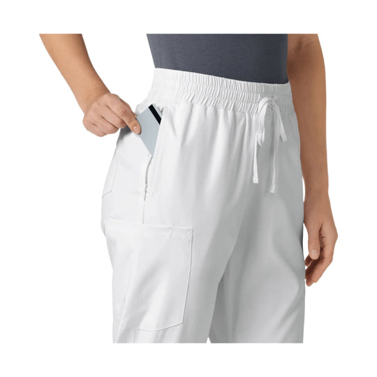 White scrub pants with elastic waistband, drawstring ties, and multiple pockets, shown on a model