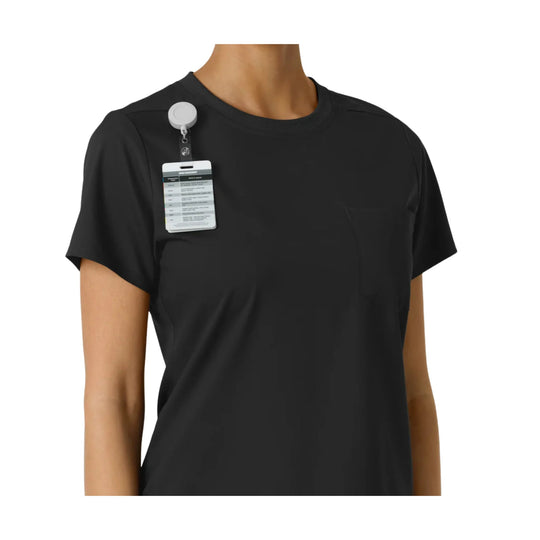 Black short-sleeve scrub top with chest pocket and ID badge clipped near the shoulder