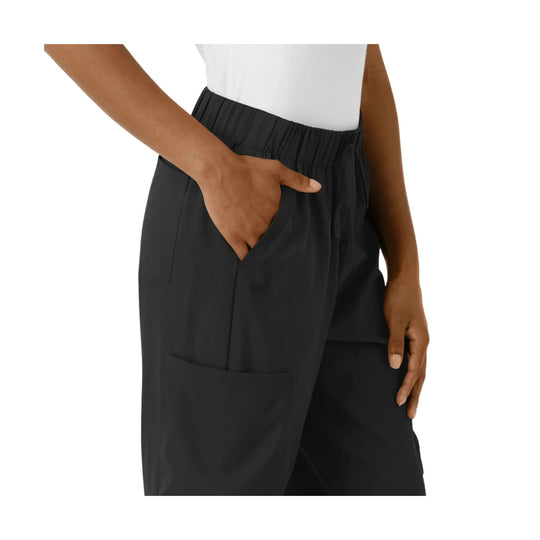Black wide-leg pants with elastic waistband and side pocket, worn on a model