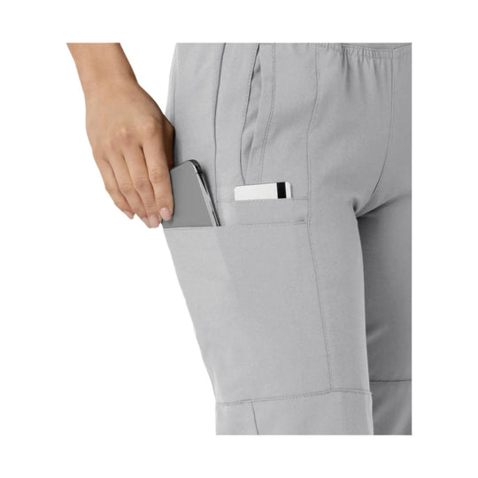 Gray cargo scrub pant pocket holding a smartphone and a card