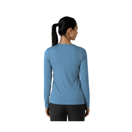 Back view of a blue long-sleeve athletic top worn by a model