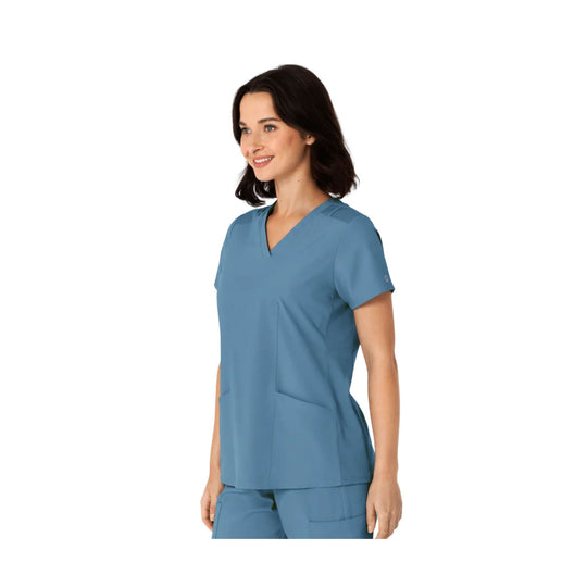 Blue V-neck scrub top with short sleeves and front patch pockets, shown on a model