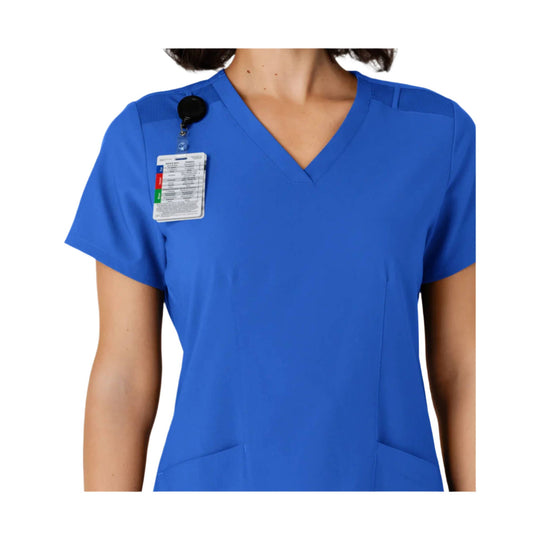 Royal blue V-neck scrub top with short sleeves and front pockets, shown with an attached badge reel and ID card