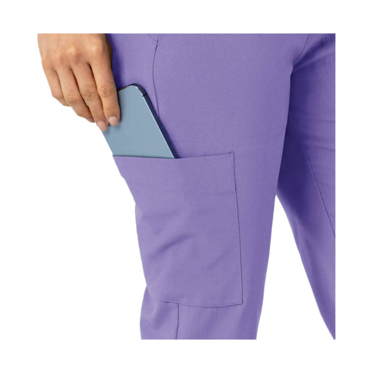Purple scrub pants with a side cargo pocket and a smartphone partially tucked in the pocket