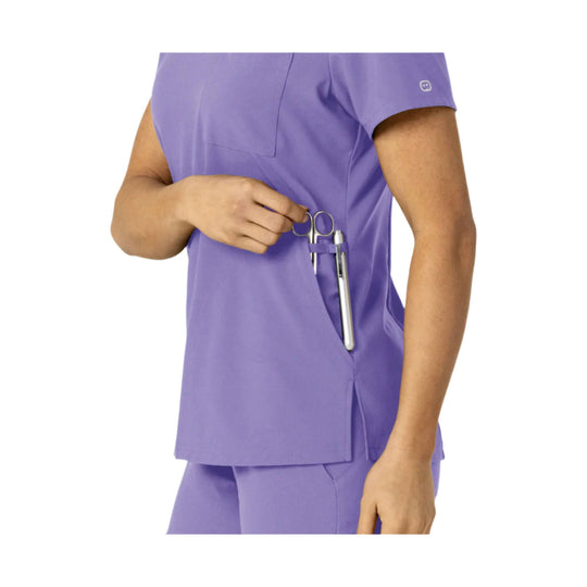 Lavender scrub top with side pocket holding medical tools and short sleeves