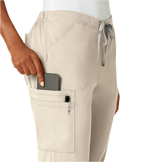 Beige scrub pants with side cargo pocket, drawstring waist, and phone in pocket