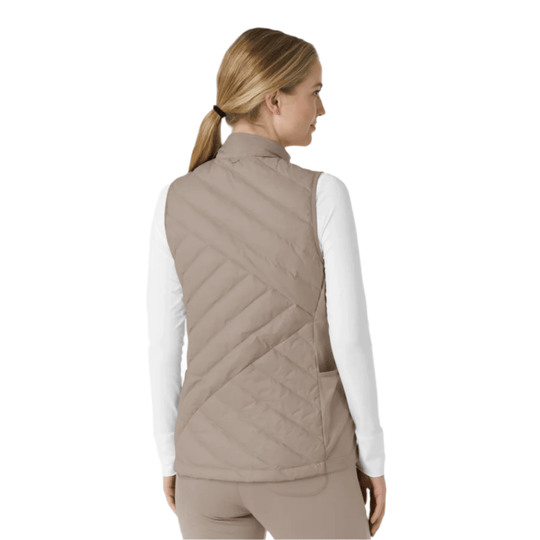 Beige quilted sleeveless vest shown from the back over a white long-sleeve top