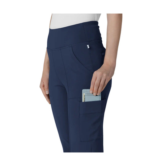 Navy high-waist cargo scrub pants with a side pocket holding a card holder