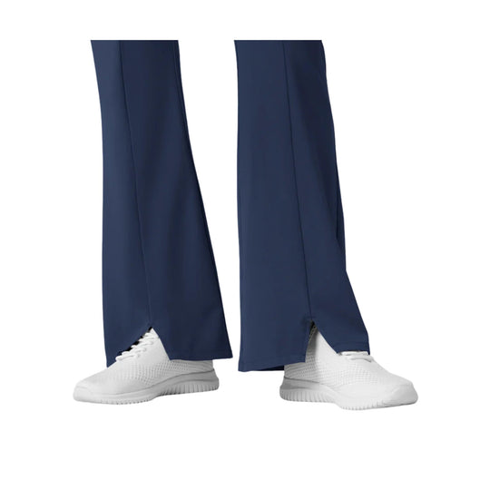 Navy flare scrub pants with split hems and white sneakers