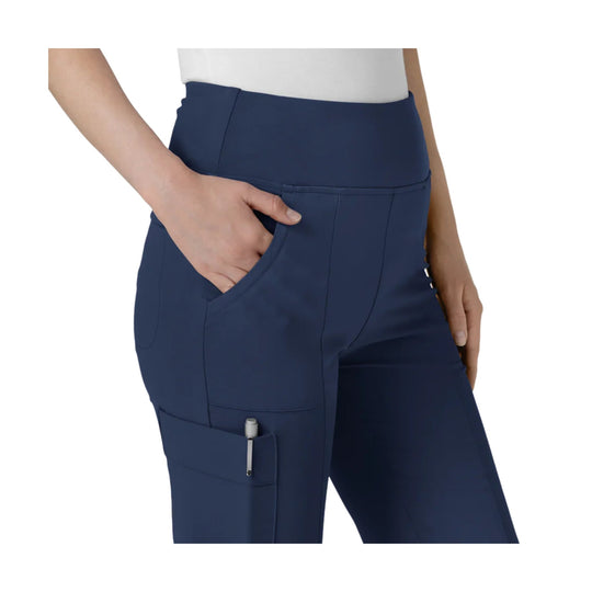 Navy high-waisted cargo scrub pants with a side pocket and flared leg, shown on a model