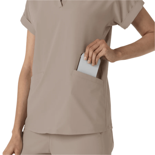 Beige short-sleeve scrub top with a chest pocket, shown with a phone tucked into the pocket