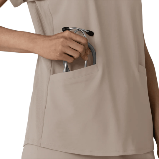 Beige scrub top with a chest pocket, shown with a stethoscope being placed into the pocket