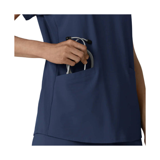 Navy scrub top with chest pocket holding a stethoscope