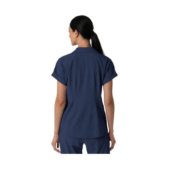 Navy short-sleeve scrub top shown from the back with rolled cuffs and a collared neckline