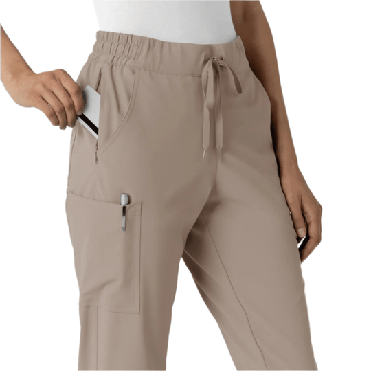 Beige women’s jogger scrub pants with elastic waistband, drawstring, cargo pockets, and a phone in the side pocket