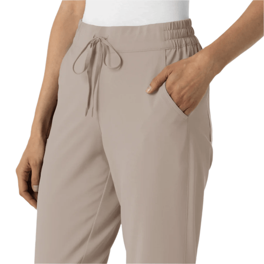Beige jogger scrub pants with elastic waistband, drawstring tie, and side pockets