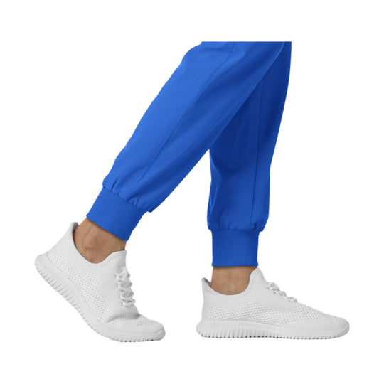 Blue jogger scrub pants with ribbed cuffs and white sneakers